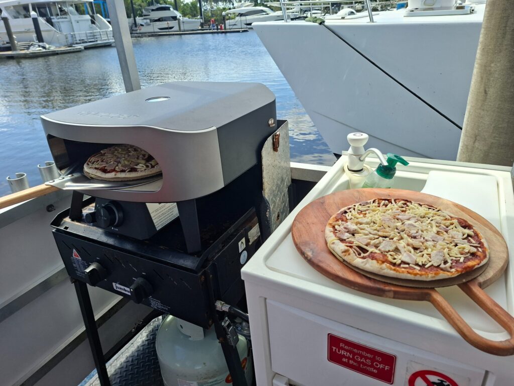 Pizza oven and pizzas ready to cook aboard a Gold Coast BBQ Boat Hire pontoon